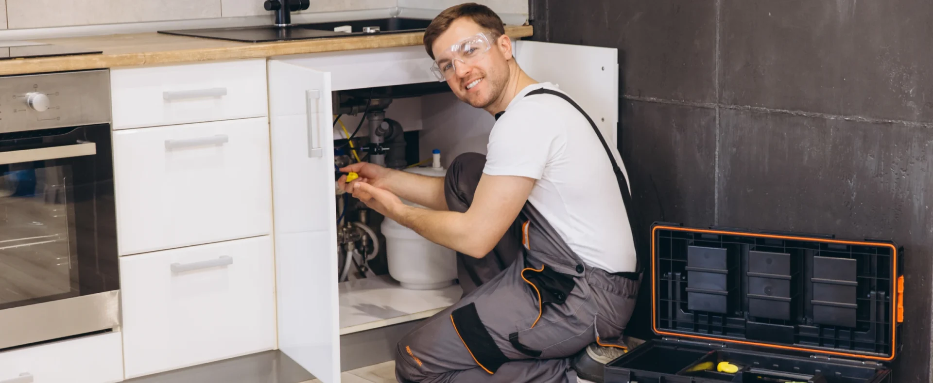 Man with tools fixing plumbing issue